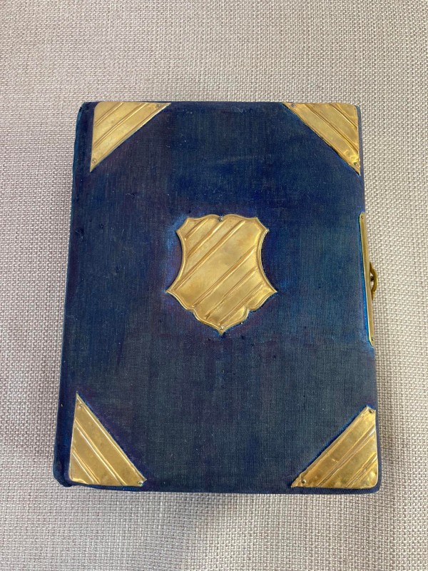 Antiek fotoboek met blauwe kaft met schild