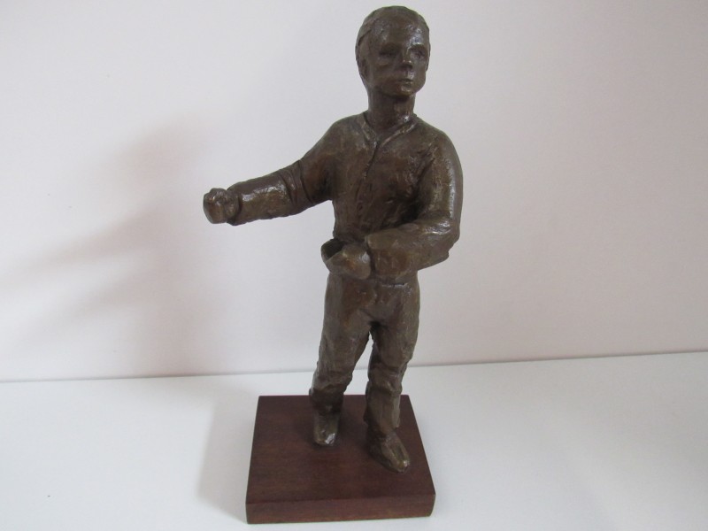 Bronzen beeld van een zaaiende man.