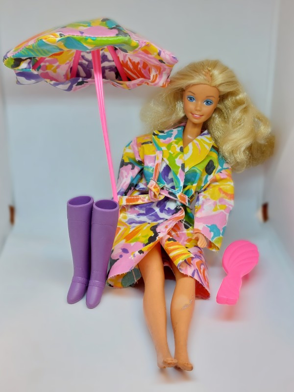 Vintage Barbie-pop met een regenjas