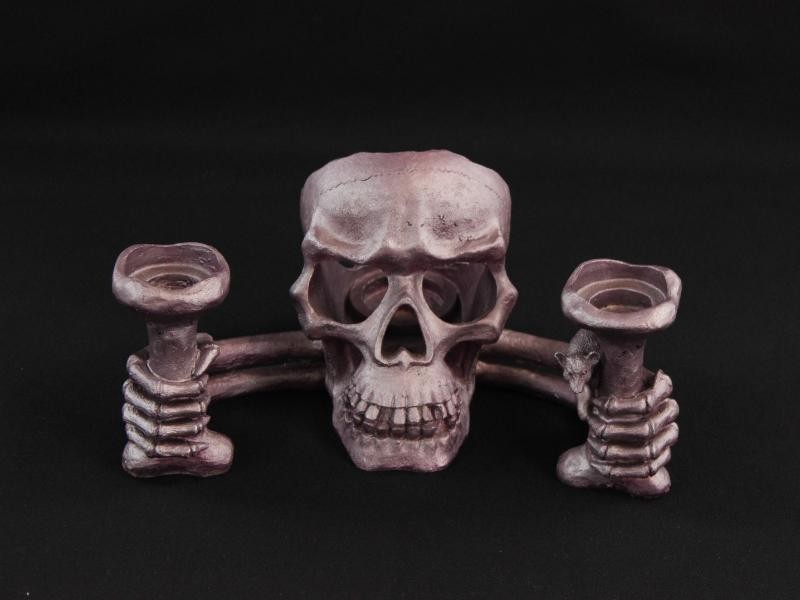 Paarse kandelaar in de vorm van een schedel.