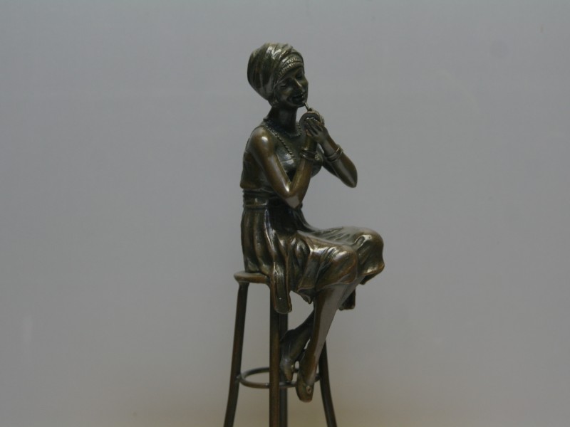 Bronzen sculptuur van vrouw op barkruk met lippenstift (Art. nr. 628)