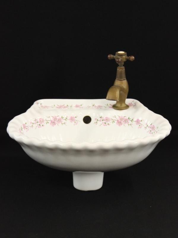 Kleine porseleinen lavabo in schelpvorm met mooie kraan
