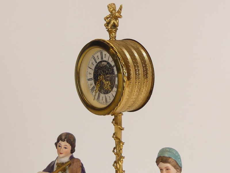 Vintage opwindbare klok met porseleinen figuren