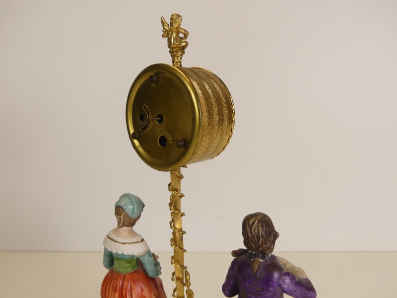Vintage opwindbare klok met porseleinen figuren
