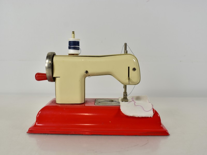 Vintage speelgoed naaimachine Regina met metalen voet.