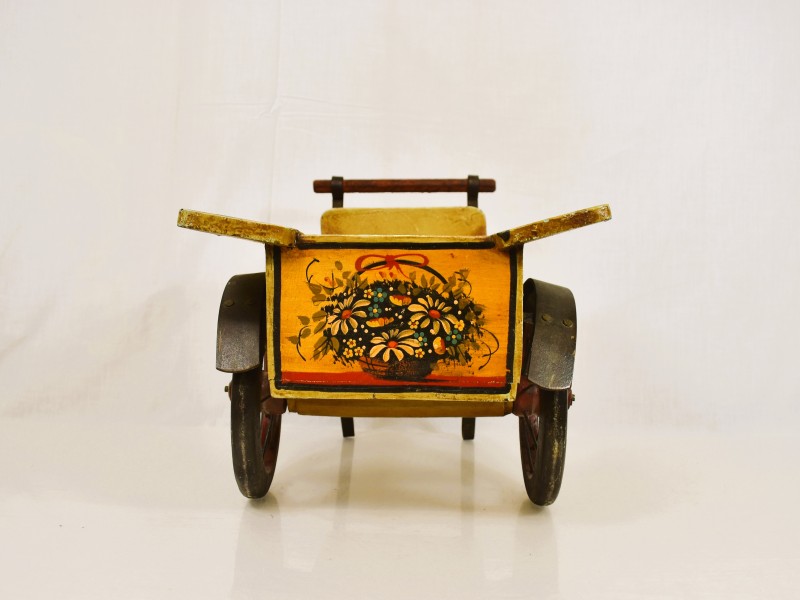Vintage houten speelgoed kar met bloemenmotief.