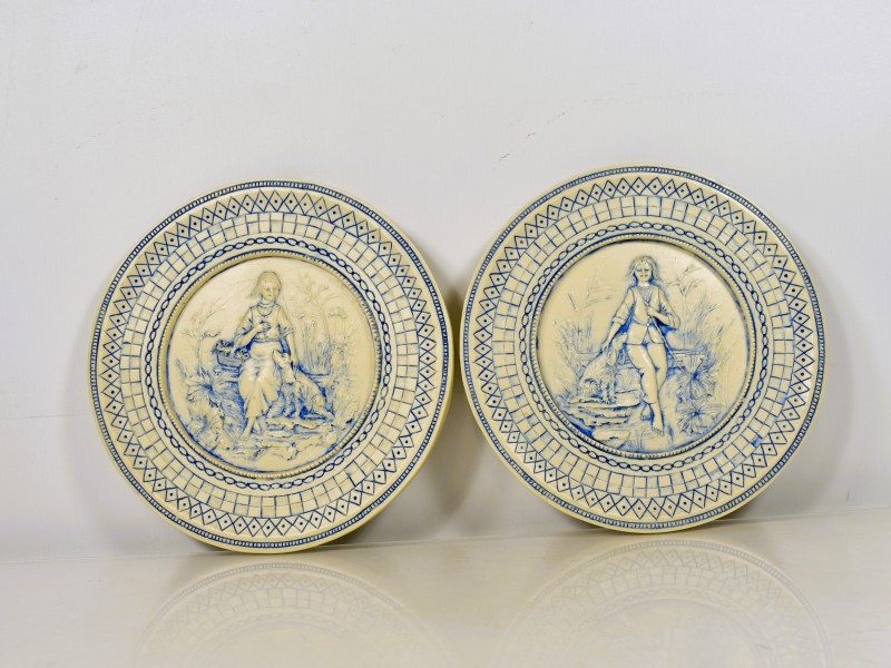 Set van 2 reliëf borden in crème en blauw aardewerk.