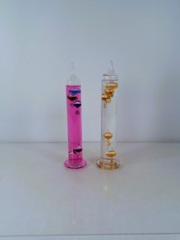 Glazen Galileo thermometer met amberkleurige vloeistof.
