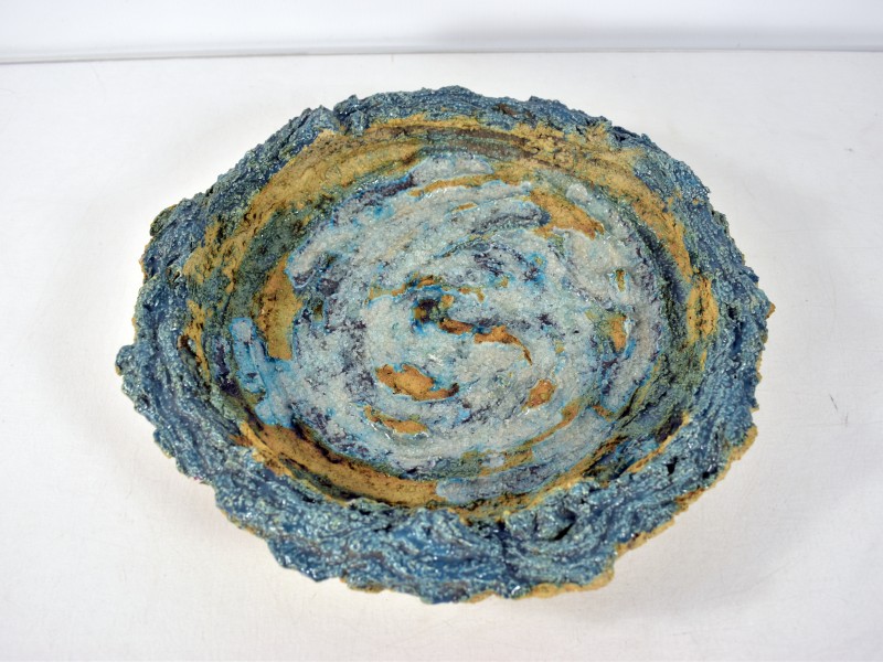 Keramische schaal met blauwe glazuur en ruwe rand.